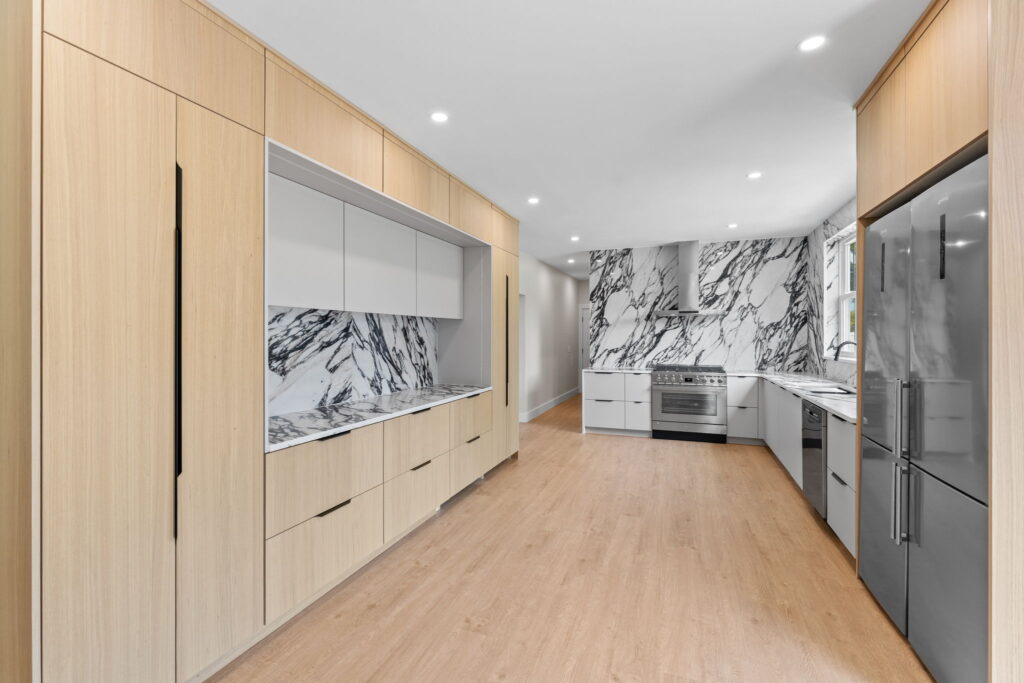 Modern full kitchen remodel in Philadelphia featuring high-end European flat panel cabinets and luxury marble walls.
